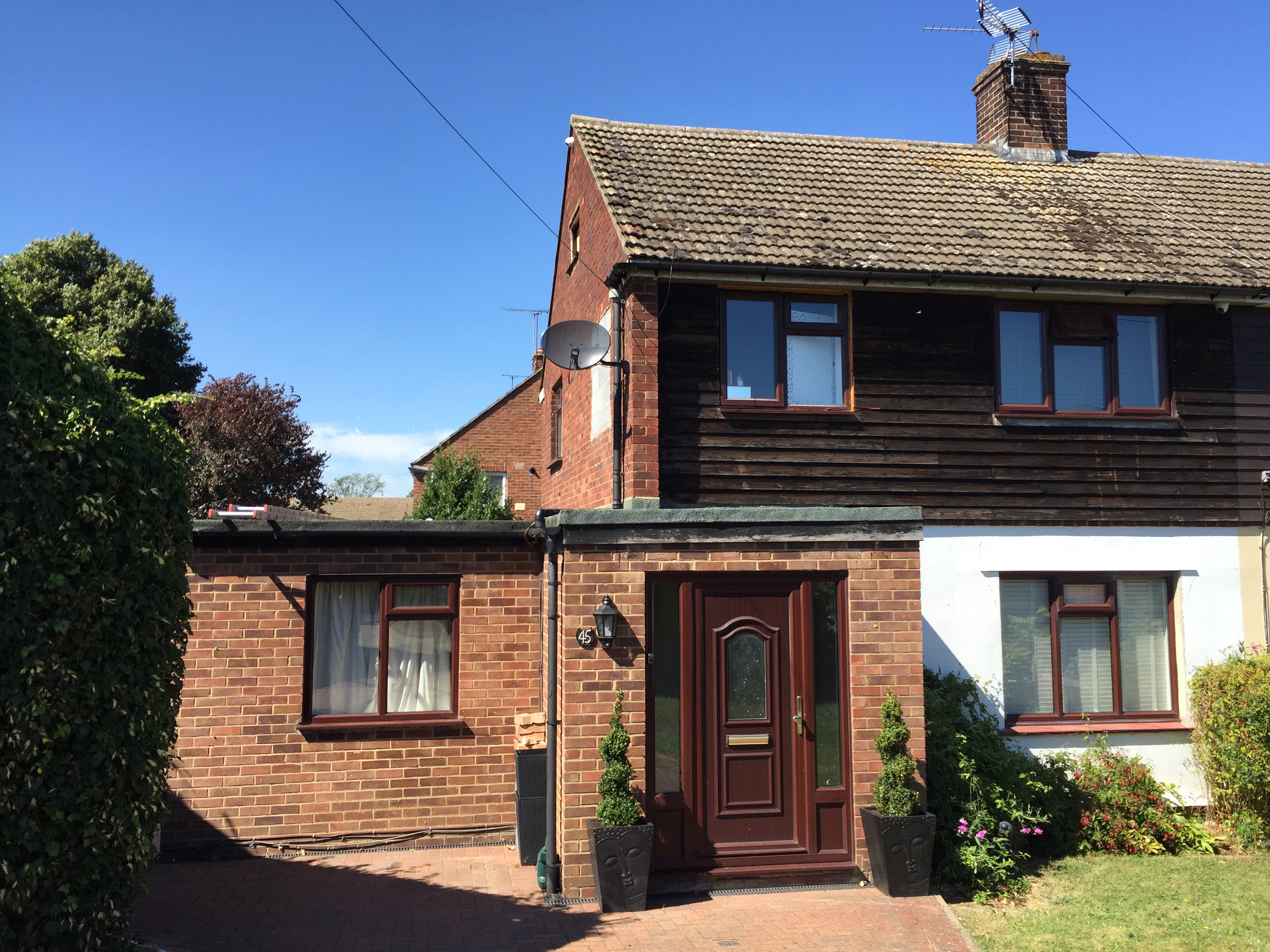 Before renovation - original property with red brick and dark weatherboarding